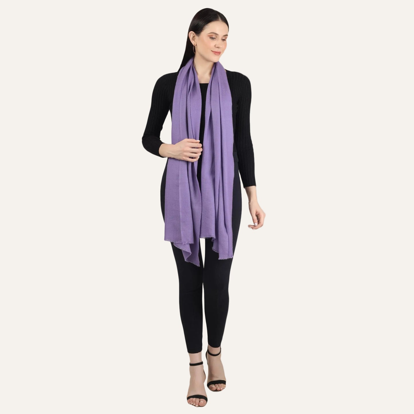 Purple cashmere scarf put around the neck by a woman standing in black dress