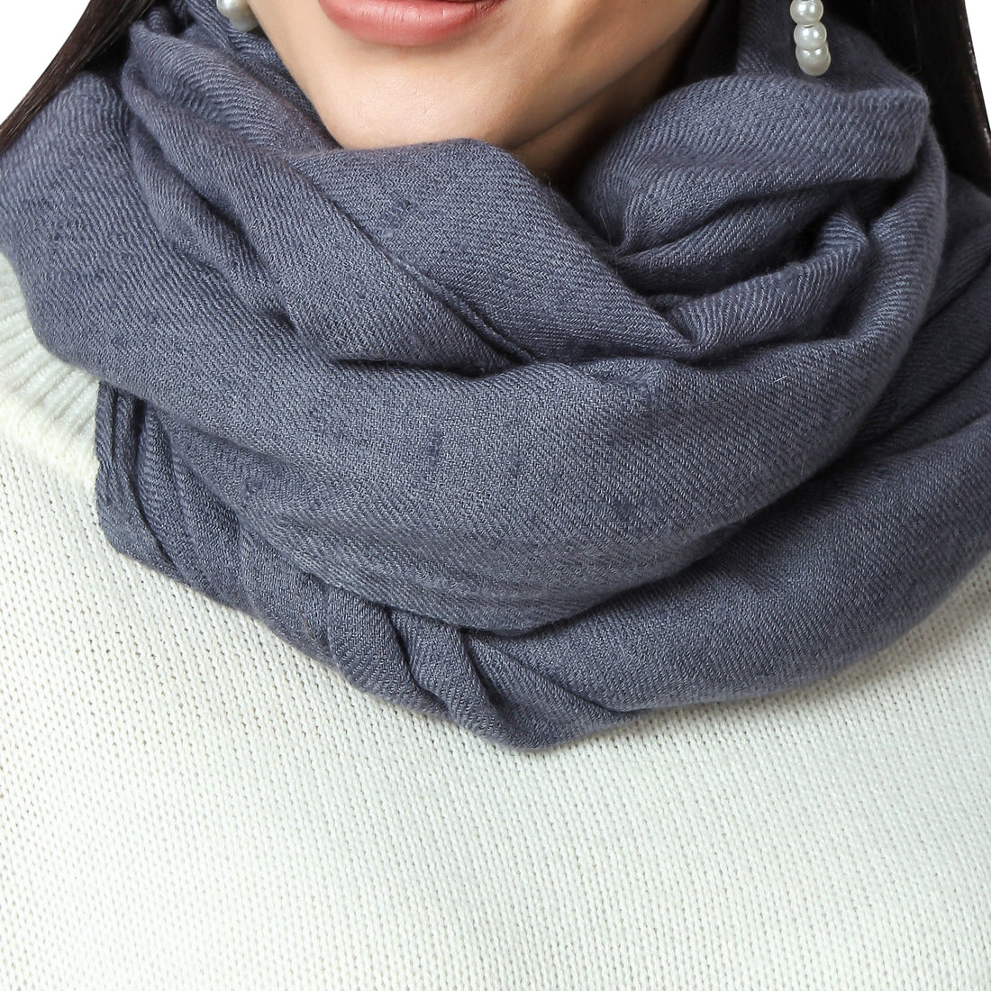 Cashmere Scarf in Grey color worn by a woman around her neck, a closeup photo of cashmere scarf showing its texture