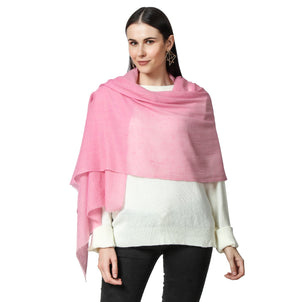 a Woman wearing a Pink Cashmere Scarf  over her white sweater and Black jeans
