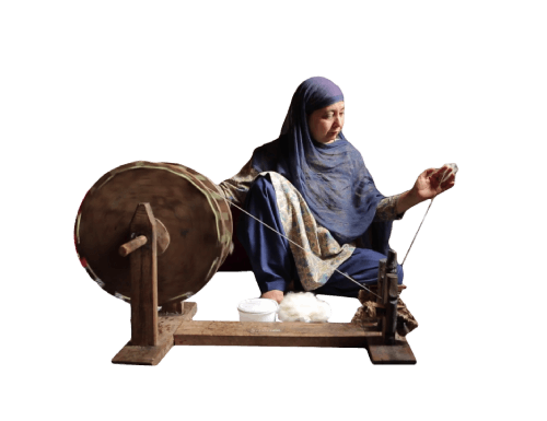 A Kashmiri woman behind a spinning wheel of making pashmina fibres into a Yarn on traditional patterns