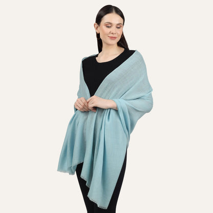 Cashmere turquoise scarf worn by a woman over a black sweater