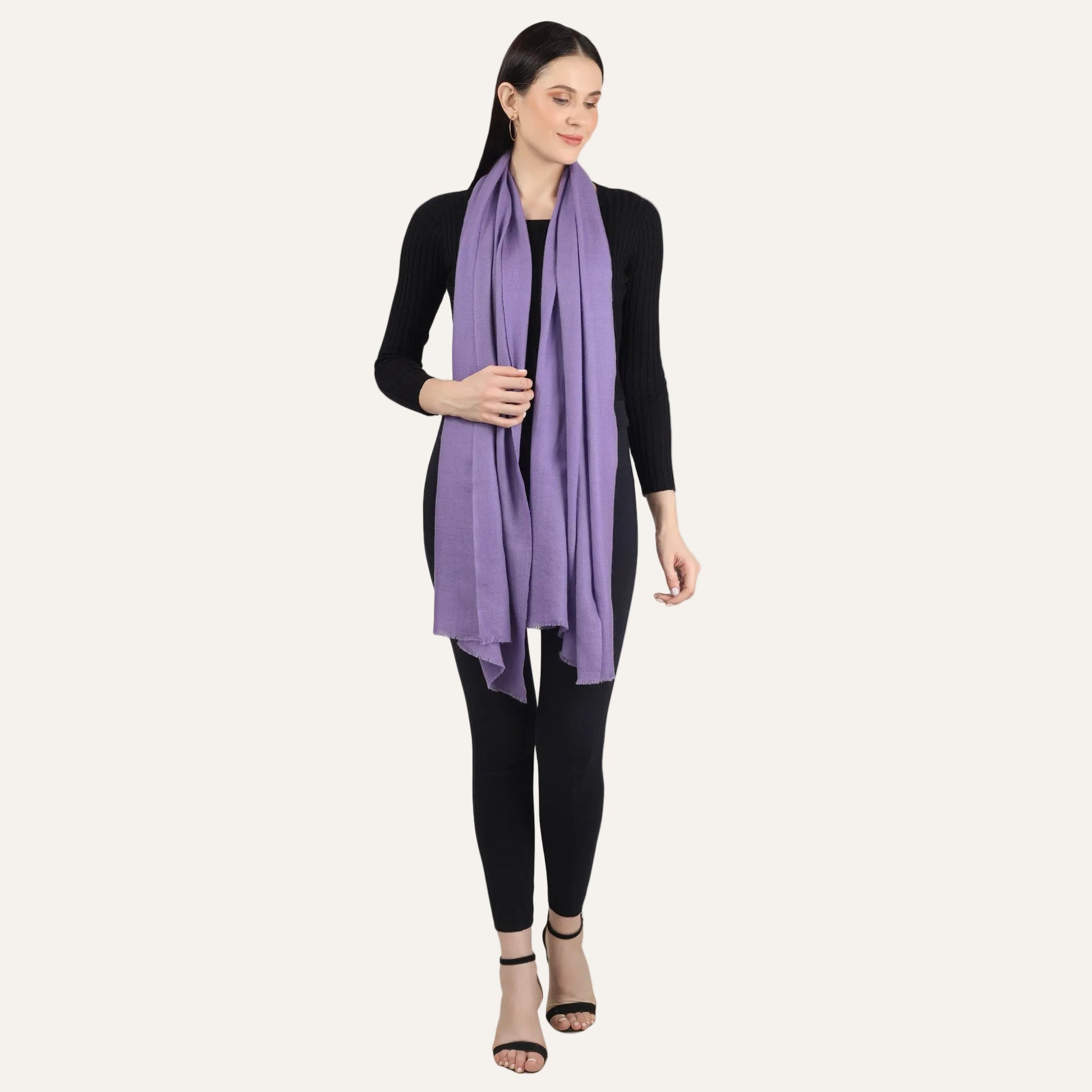 Purple cashmere scarf put around the neck by a woman standing in black dress