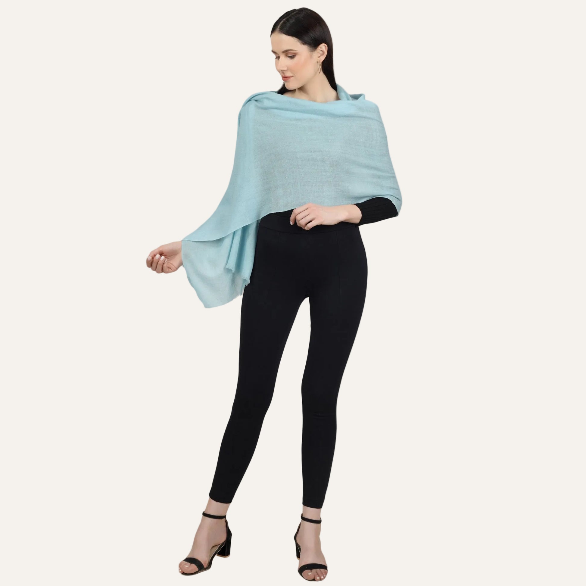 Woman wearing a turuoise cashmere scarf over a black dress